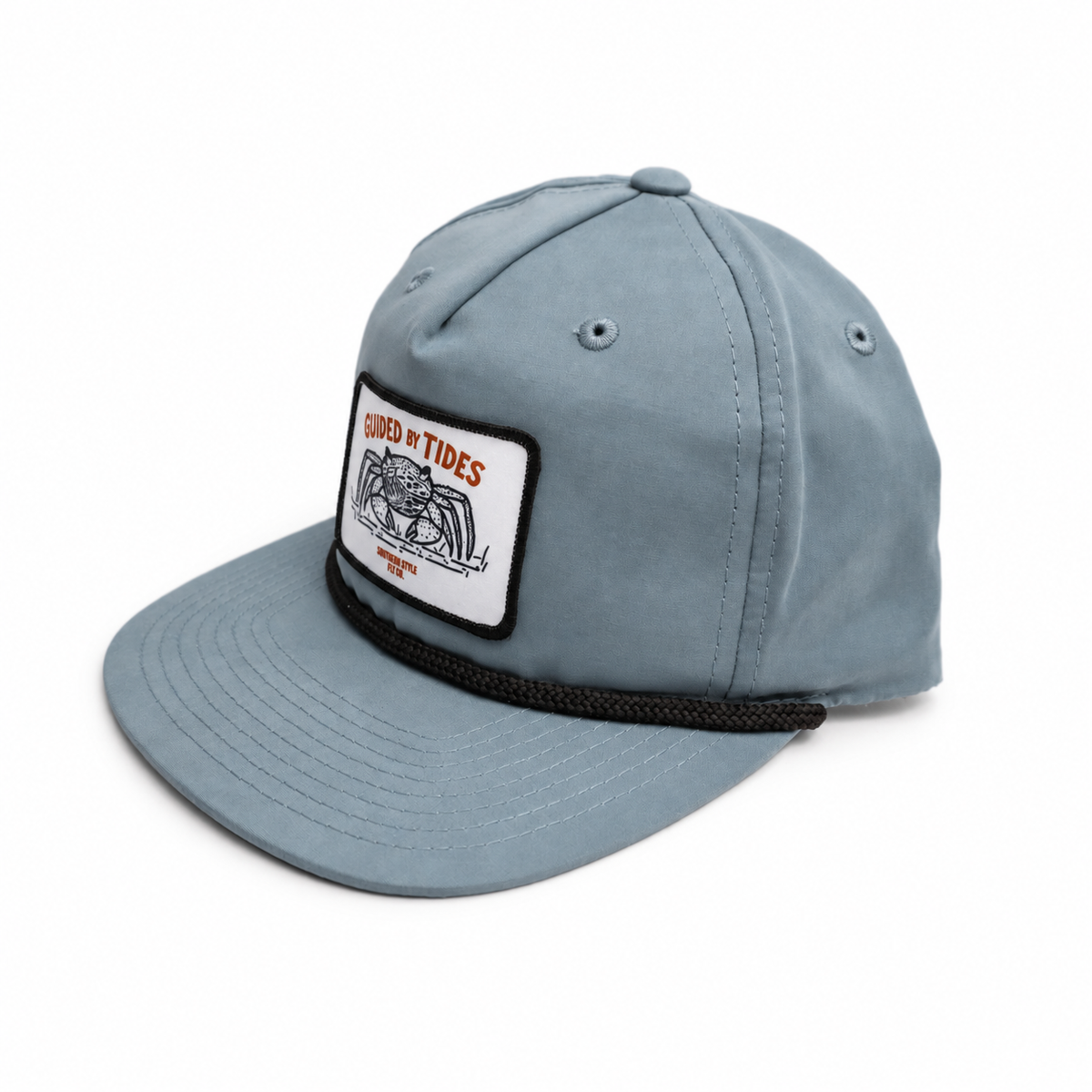 Angled view of the slate-blue Mangrove Rope Hat showing its five-panel crown, flat bill, black rope and crab patch.