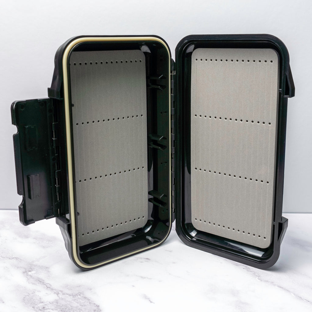 Black hard-shell waterproof fly box with foam slots for saltwater flies with compact size and durable build