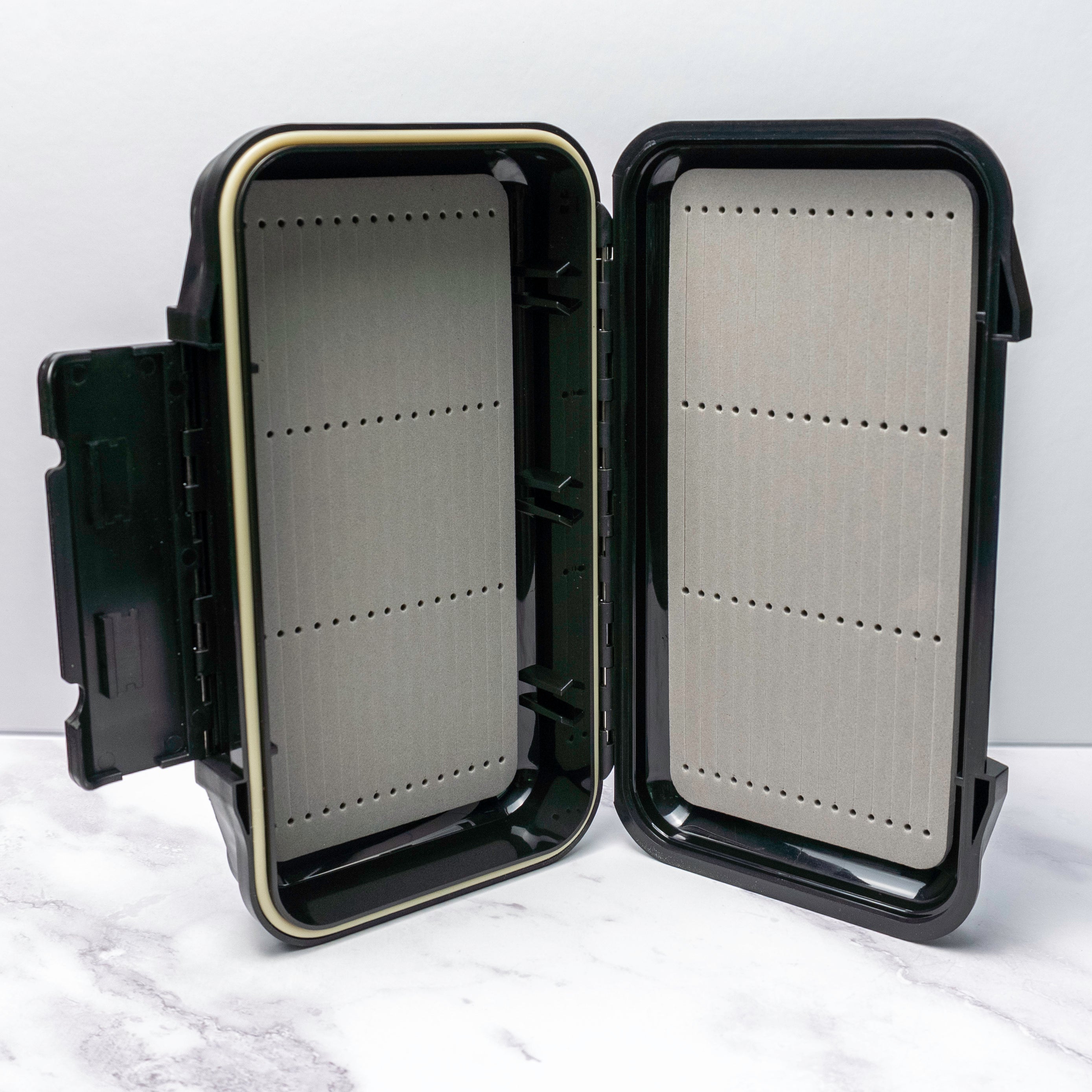 Black hard-shell waterproof fly box with foam slots for saltwater flies with compact size and durable build