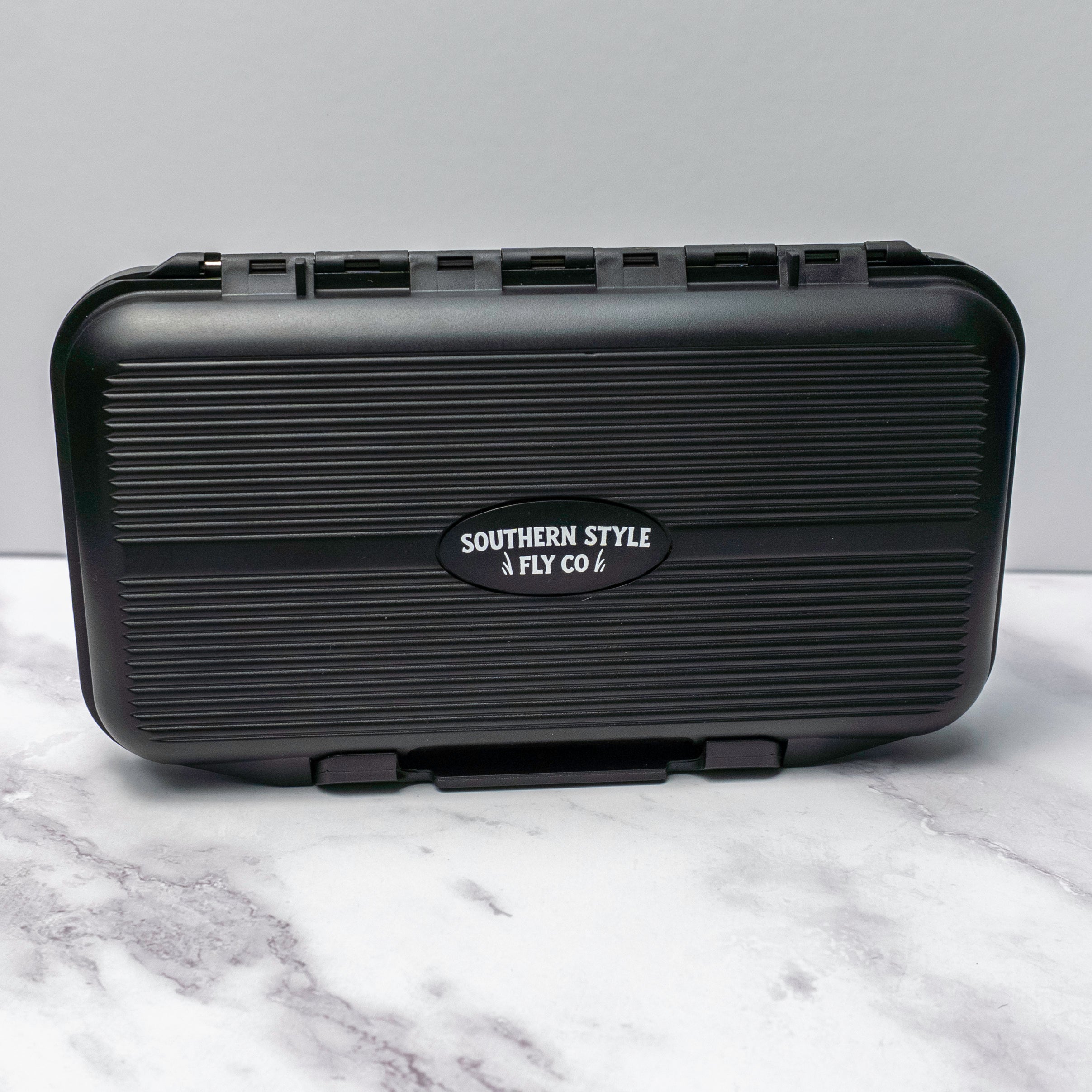Black hard-shell waterproof fly box labeled Southern Style Fly Co designed for saltwater flies with compact size and durable build