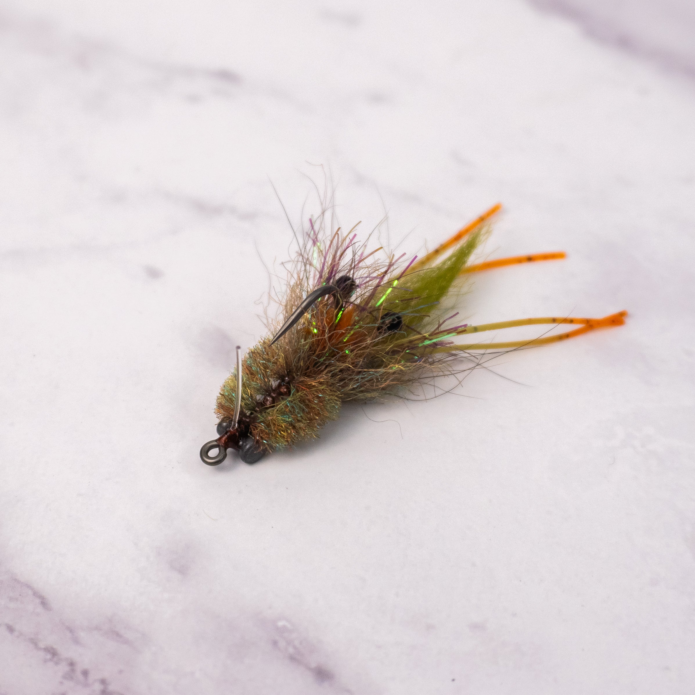 Olive Bandit Crab fly with rubber legs, flash, weighted eyes, and weed guard for redfish and shallow water fly fishing