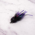 Black and purple Bandit Crab fly with flash, rubber legs, weighted eyes, and weed guard for low light redfish fishing