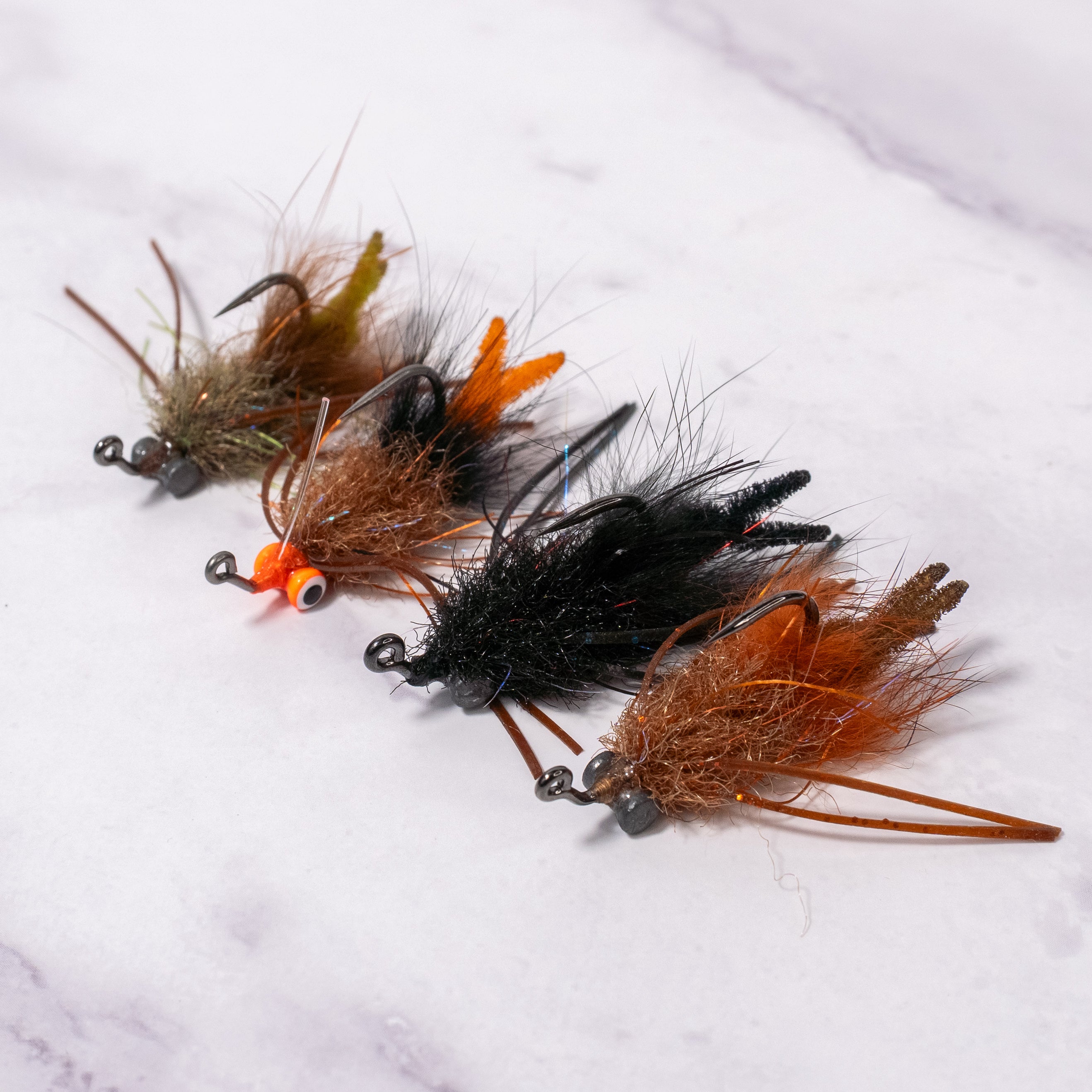 Bourbon Crab fly in brown/rust and black color variations shown together, small minimal crab pattern for redfish and black drum