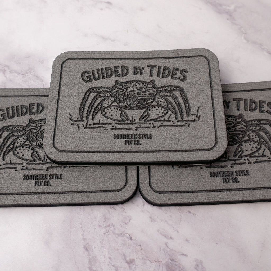 Gray 2.8 x 4 inch Southern Style Fly Co. peel-and-stick foam fly pad featuring the Guided by Tides mangrove crab logo, designed for mounting on fly boxes, coolers, and boat consoles.