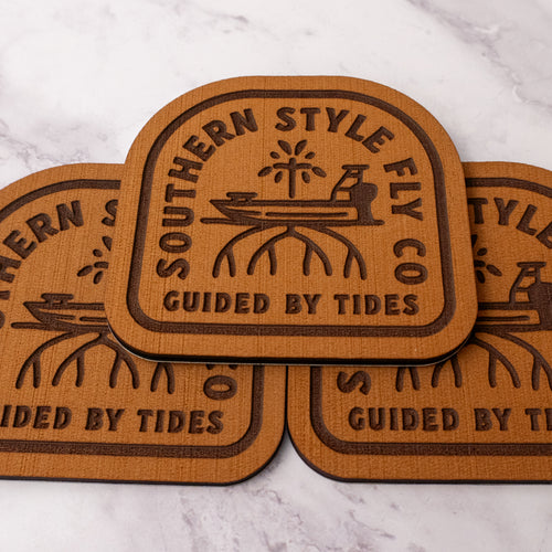 Tan 3.7 x 4 inch Southern Style Fly Co. peel-and-stick foam fly pad featuring the Guided By Tides Skiff logo with a skiff and mangrove design, built for mounting on fly boxes, coolers, and boat consoles.