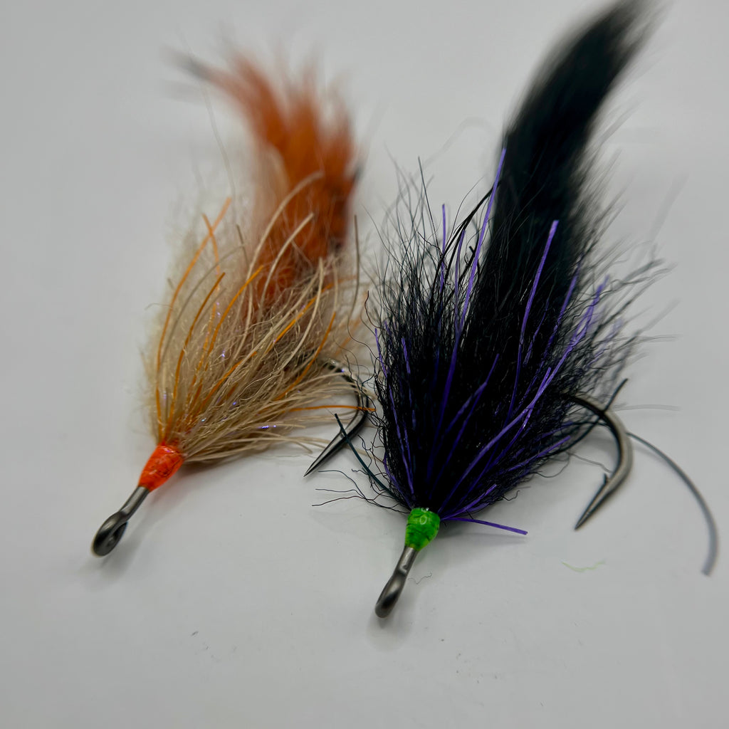 Tarpon Cigar fly in purple/black and tan/rust color variations showing long, slim profile and subtle saltwater materials