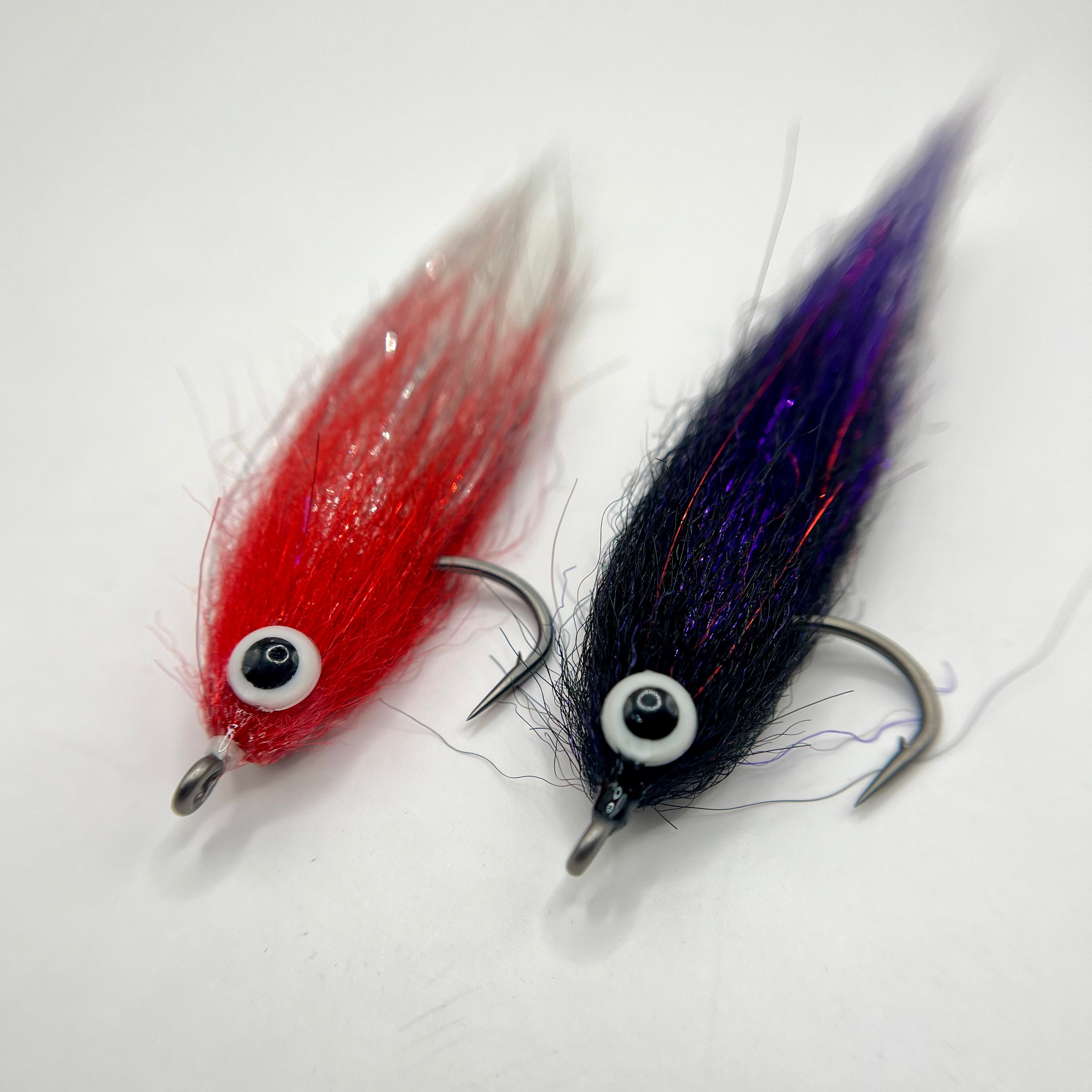 Wake Maker Mullet fly in black/purple and red/white color variations showing wide-profile mullet design and flash details