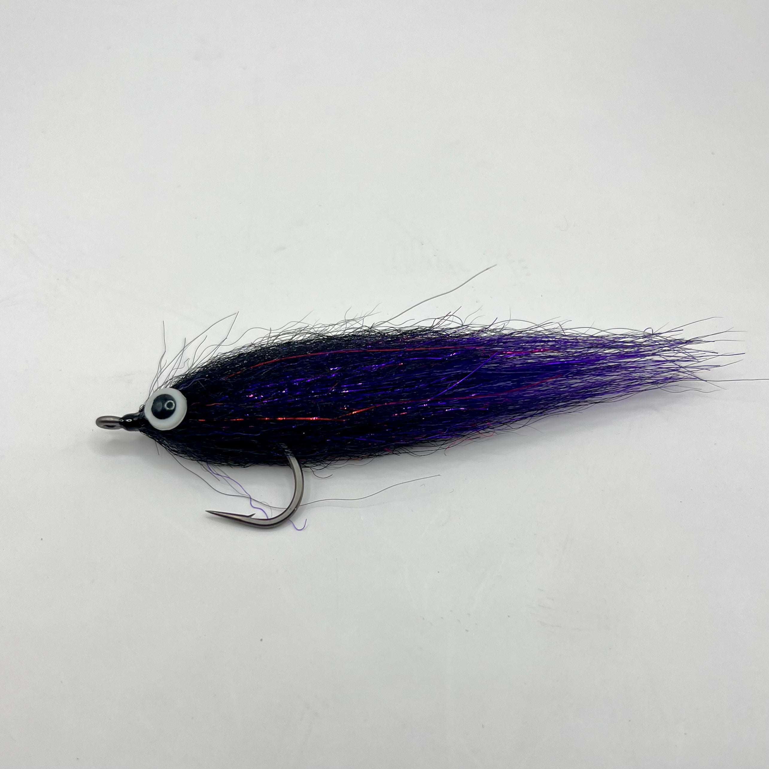 Full profile view of Wake Maker Mullet fly in black and purple, wide-body mullet pattern designed for tarpon and snook