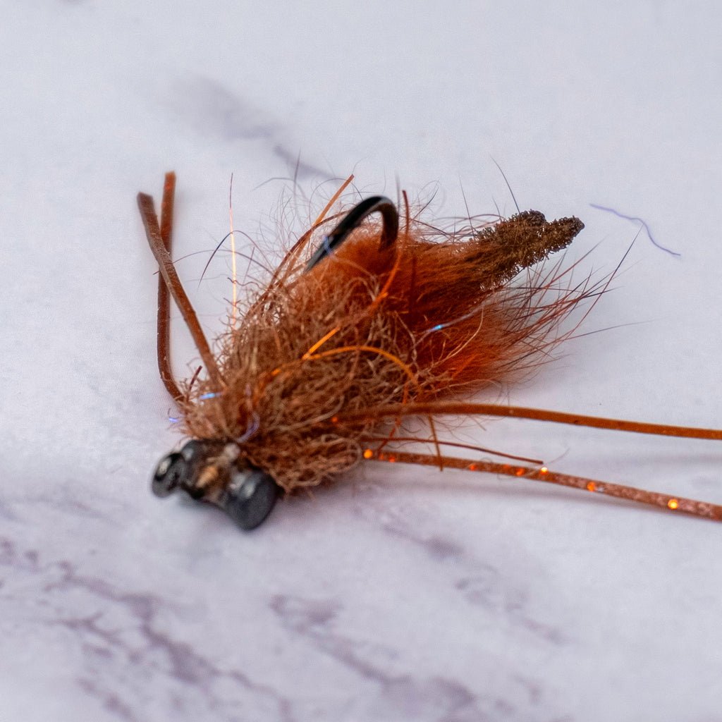 Macro view of Bourbon Crab fly in brown and rust colorway showing EP brush body, silicone legs, and Strong Arm style claw