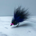 Black and purple South Bounder tarpon fly with subtle flash accents tied on a Size 1/0 Mustad Big Game Hook for low-light and dirty water conditions.
