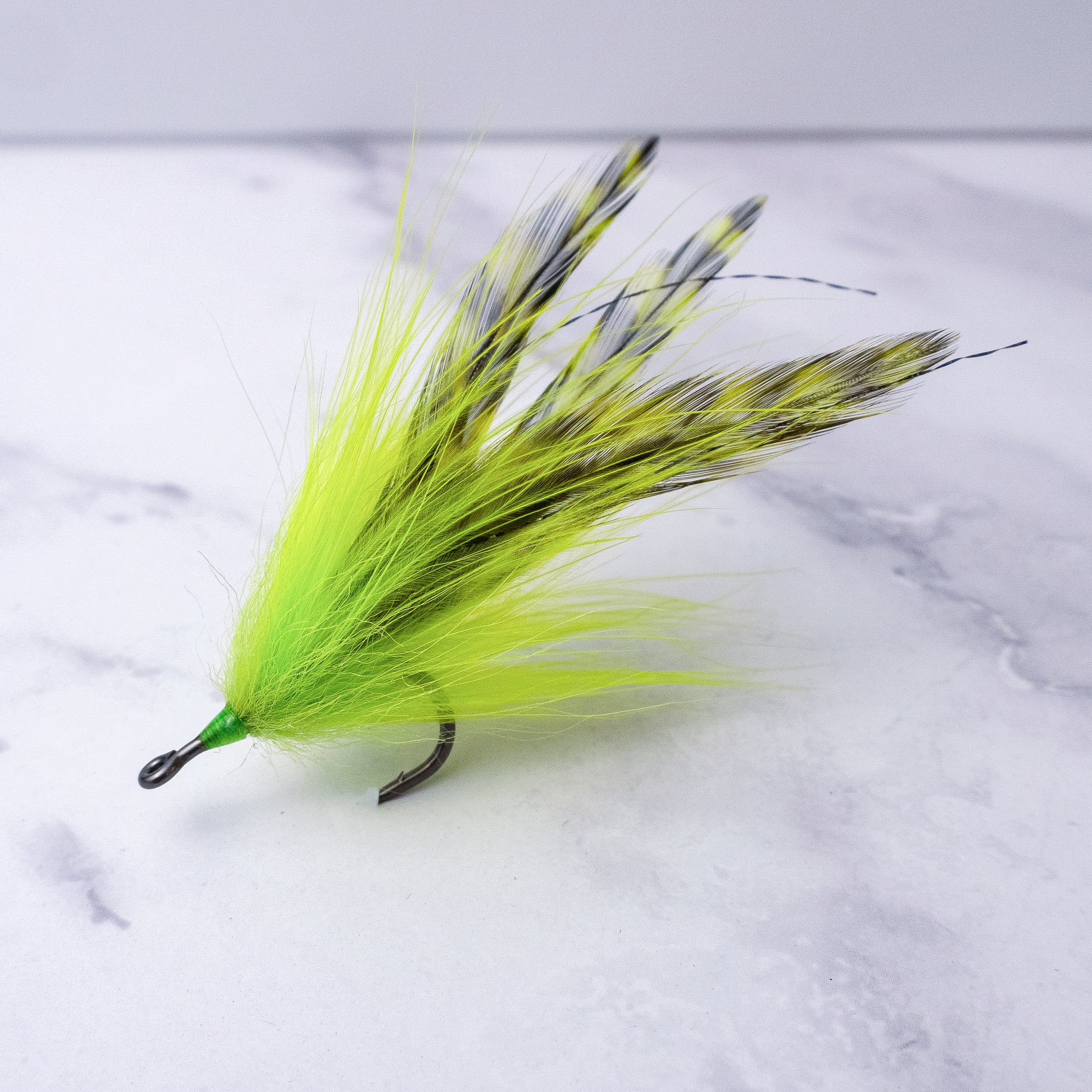 Chartreuse Southern Roach tarpon fly with bright synthetic hair and barred saddle hackles tied on a premium saltwater streamer hook.